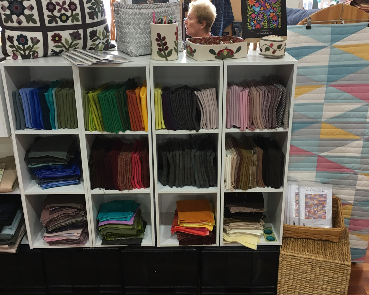 Pre-cut fat quarters shown on a white shelving unit